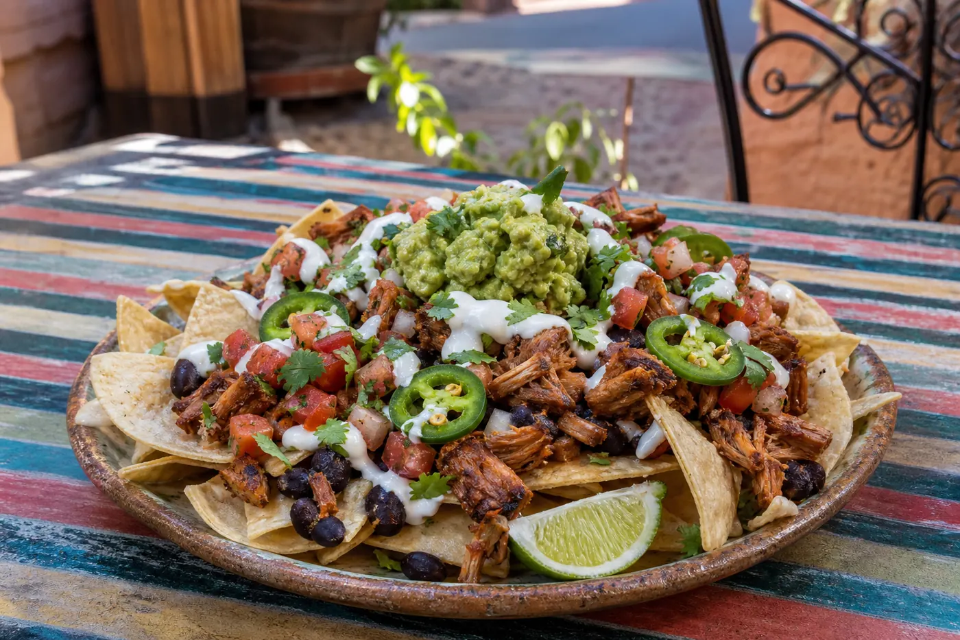 Loaded vegan nachos with jackfruit carnitas, guacamole, pico, jalapeno, and cashew crema
